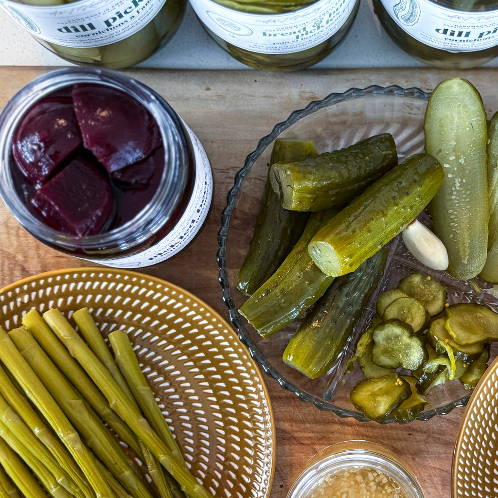 Assorted pickled vegetables and condiments on a wooden surface.